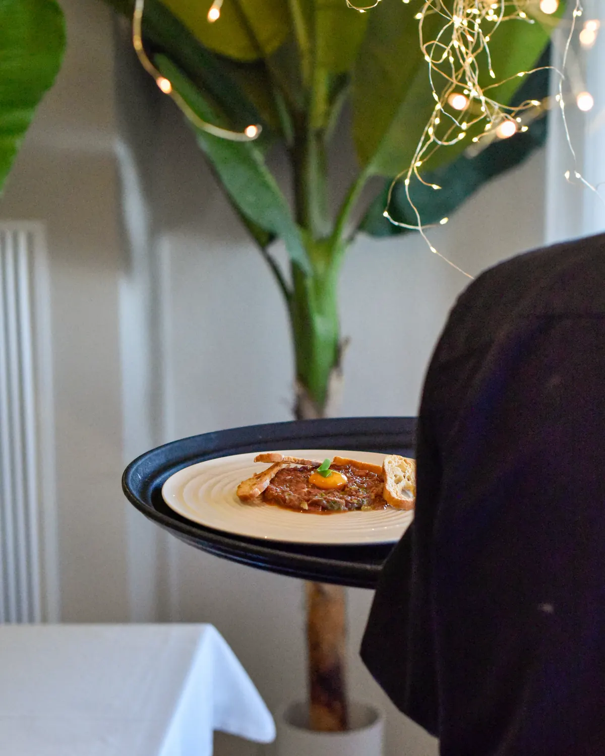 Cambrer portant un plat acabat d'emplatar